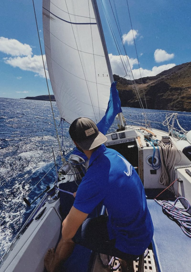 Crew member handling the sail on a private sailboat off Madeira