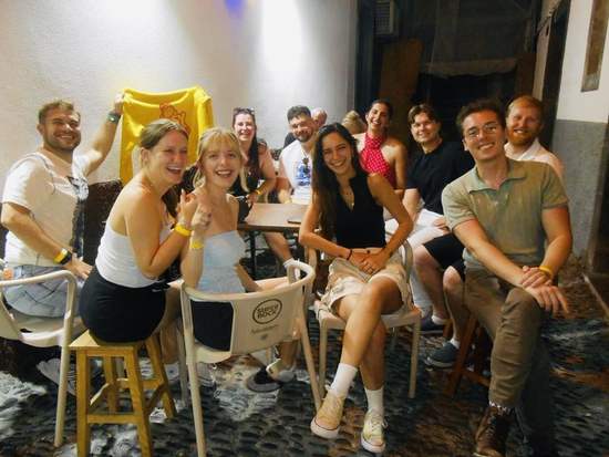 Friends sitting at a table at a Funchal bar during a night tour