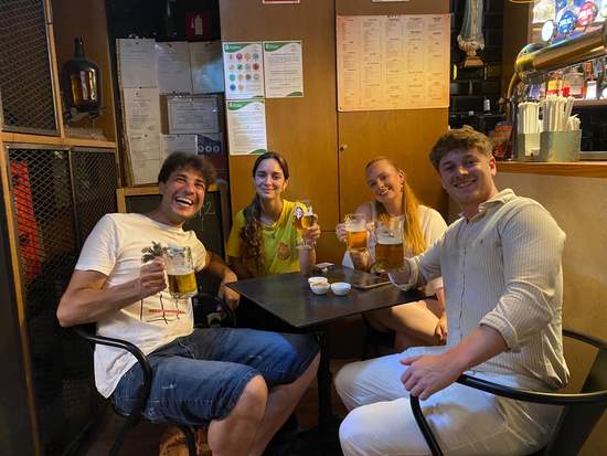 Friends laughing over beers at a traditional bar in Madeira