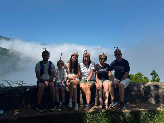 Guests sitting on a wall above the clouds at a Madeira viewpoint